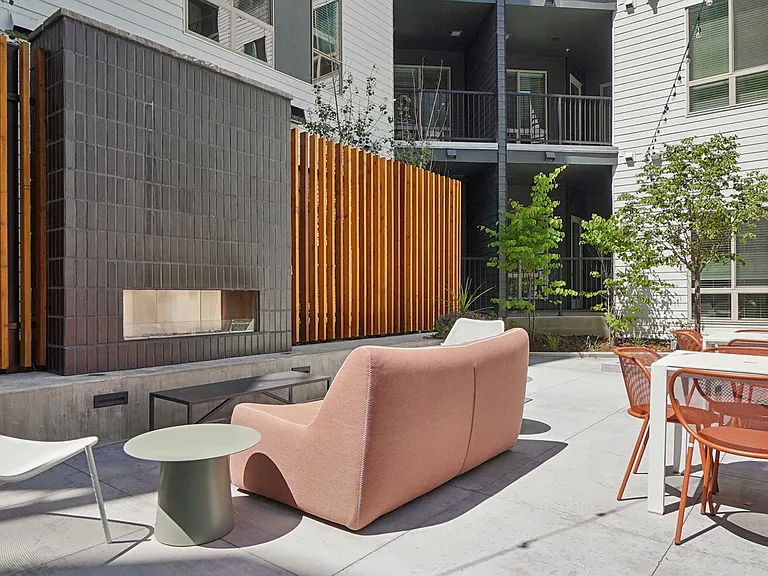 Gather with friends in the courtyard lounge featuring contemporary seating, dining areas, and a modern outdoor fireplace.