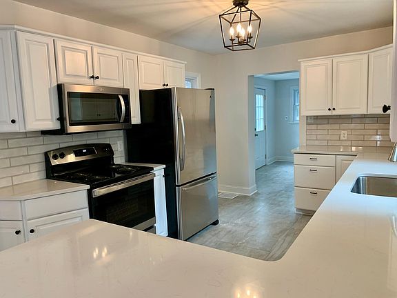 Stainless steel appliances with designer backsplash and quartz countertops