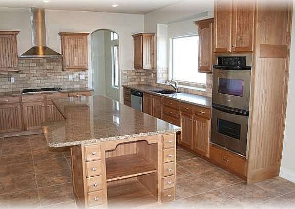 Spacious kitchen with granite and stainless steel.