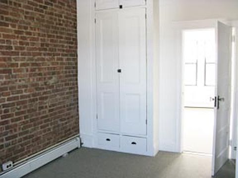 NORTH BEDROOM with exposed brick and closet leads to South BEDROOM with closet