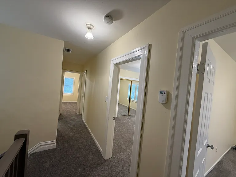 Upstairs hallway leads to four bedrooms and the primary full bath