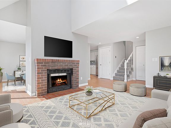Main Level ; Living area with vaulted ceilings and wood-burning fireplace *virtually staged*
