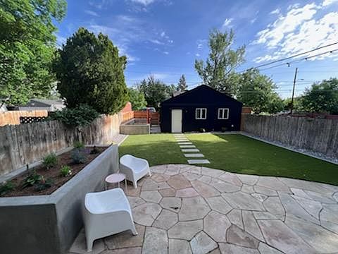 Freshly redone yard with patio. Flower in planters are now mature and beautiful.