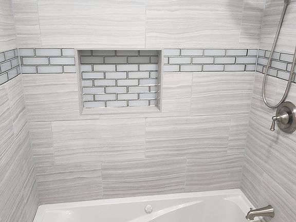 Double headed shower with a relaxing jacuzzi-style bath tub.