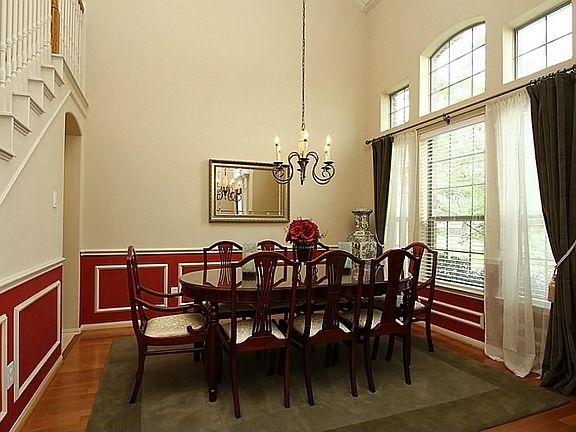 The elegant formal dining has a soaring ceiling, beautiful wall of windows plus chair-rail and pictu