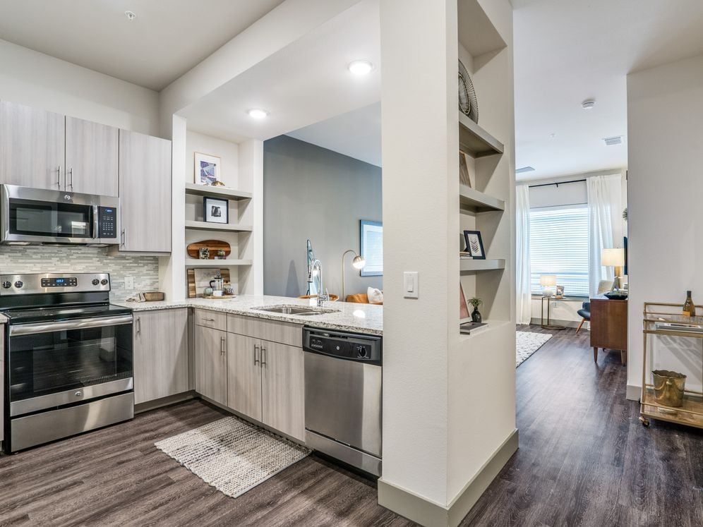 Gray finish package kitchen, living, and dining area with hard surface flooring throughout