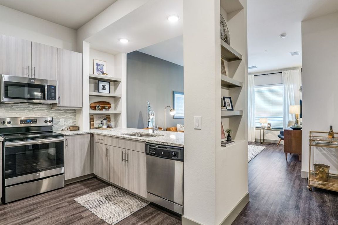 Gray finish package kitchen, living, and dining area with hard surface flooring throughout