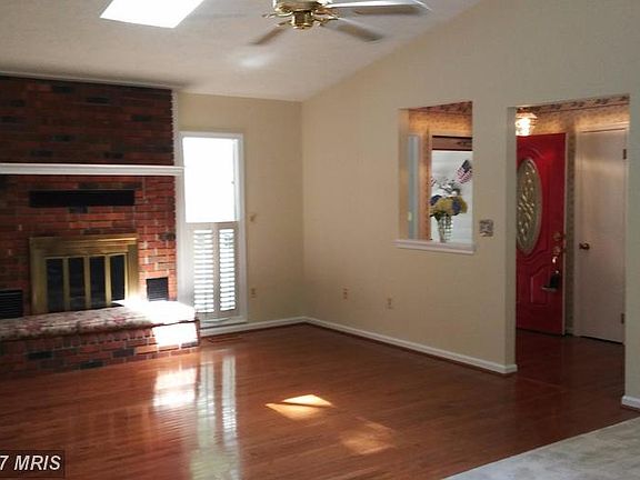 Cozy Brick Fireplace and Plantation Shutters