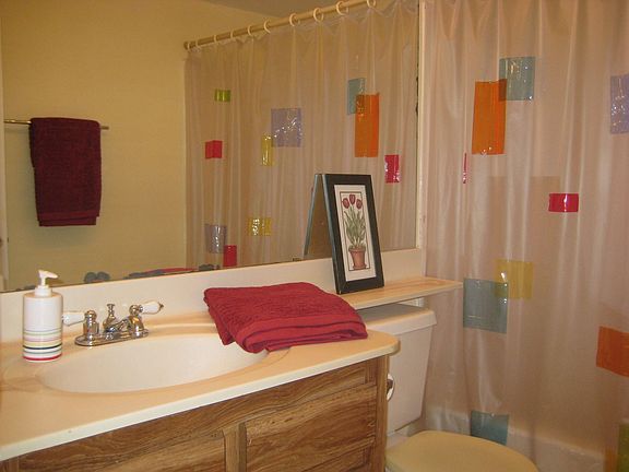 Hall bath has extended vanity and extra large mirror.