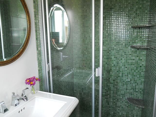 Beautifully floor-to-shower walls tiled mosaic bathroom. Vintage mirror.