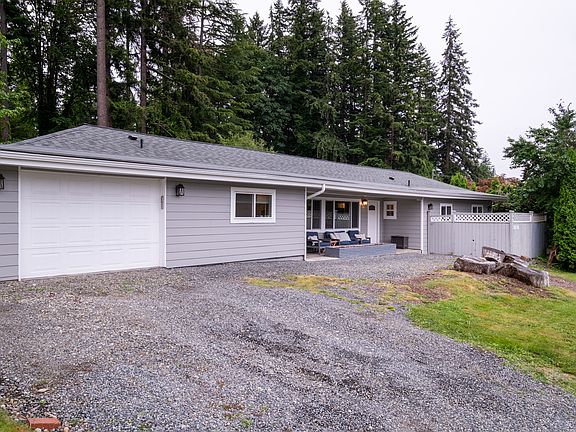 The one-car garage and large driveway offer convenient parking, while the fenced-in patio features giant arborvitae for added privacy.