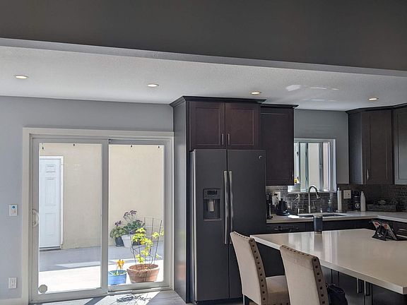 Kitchen from the other direction. Not visible on the left is the half bath, full-size clothes washer and dryer in a closet in the corner. It is behind wood folding shutter doors. By the washer & dryer, there is another hinged, glass door (left of the slid