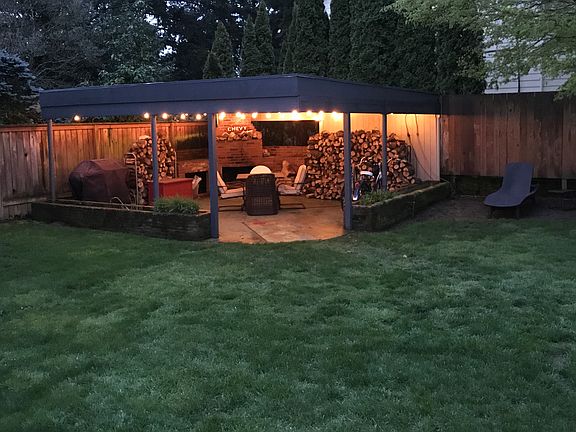 Fully fenced in Backyard with a 20' x 20' covered patio with fireplace, wood to burn, propane grille, plenty of furniture to get comfy cozy on.