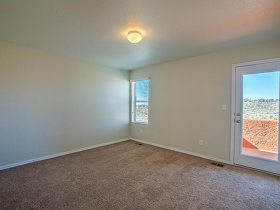 Spacious master bedroom has tons of natural light and access to a private patio