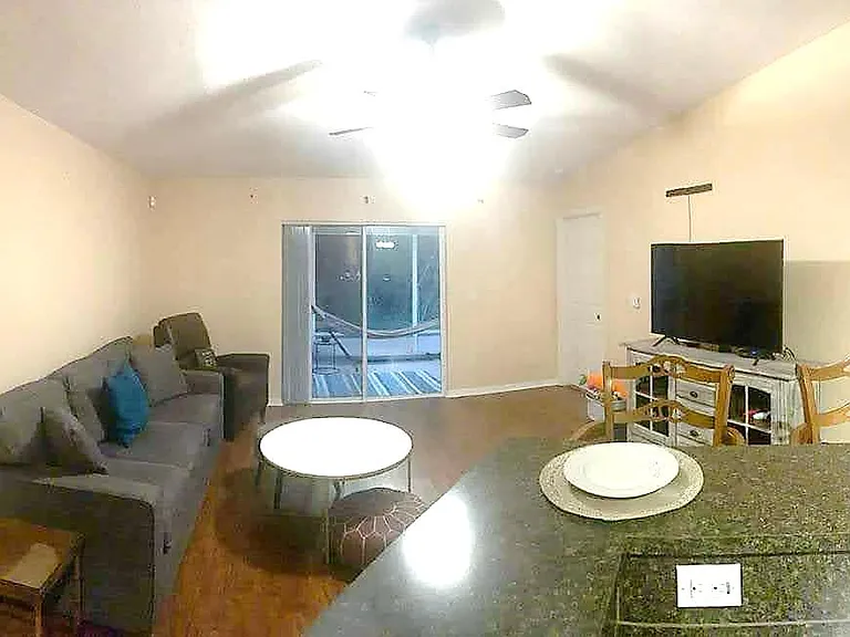 large living area off of the kitchen leads out to lenai (screened in back porch) and master suite