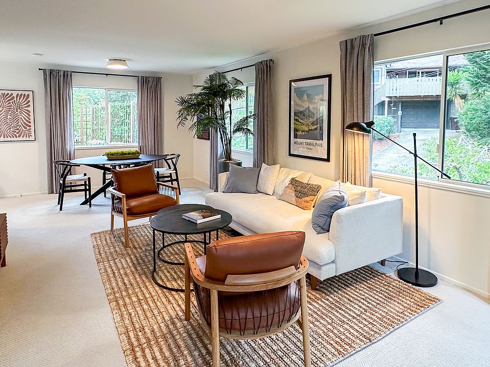 Mid-century modern furnishings. Comfortable sofa + leather accent chairs.
Large smart TV for streaming. Oversized windows with lush green views. Open layout perfect for relaxing or working from home.