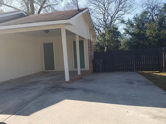 Close up view of Carport, back entrance and storage area under carport. Parking areas and entrance to backyard. Freshly painted fence!