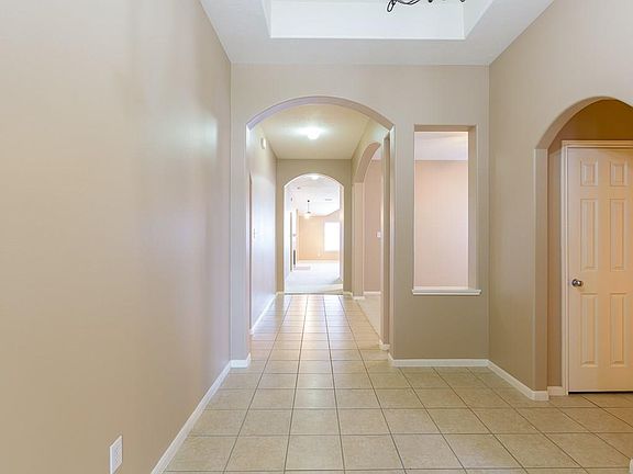 Enter the home on extended tile flooring and high ceilings overhead. The arched entries give the home lovely appeal. All interio