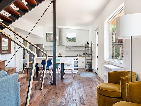 dramatic staircase between the kitchen/dining and living room