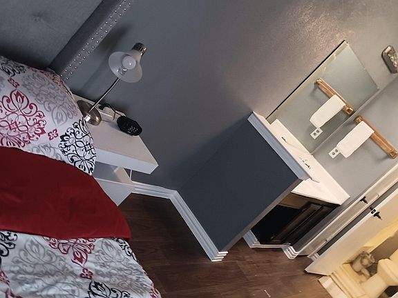 Furnished bedroom with a bed, nightstand lighting, and an en-suite bathroom for added convenience and privacy.