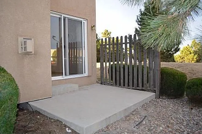 Rear patio; a separate parking lot is to the right, behind the building; as well as additional street parking, in the background.