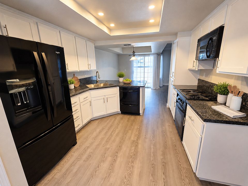 Open-concept kitchen flows seamlessly into the dining and living areas, creating an ideal space for entertaining. (Photo has been virtually staged.)