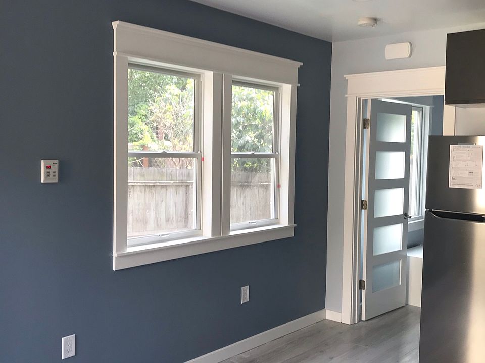 Large picture windows with backyard view, lots of light, designer accent walls