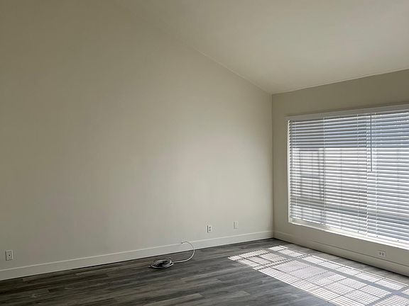 Main level living room with sloped ceilings and large window for lots of natural light