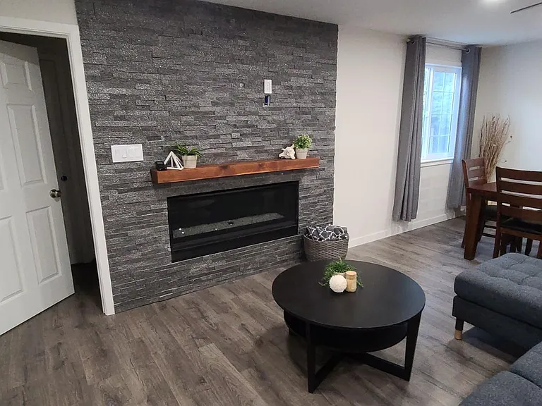 Living room with stone fireplace wall