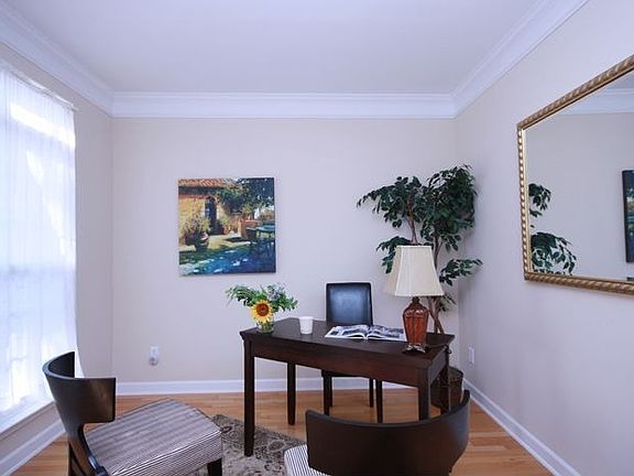 Living room/study has arched entrance, hardwood & crown molding