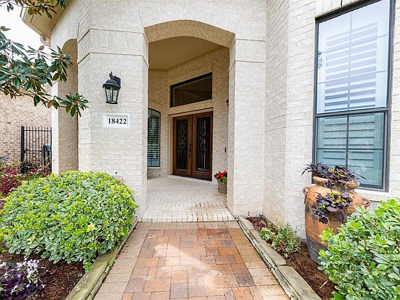 Lush landscaping escorts you to the front porch.