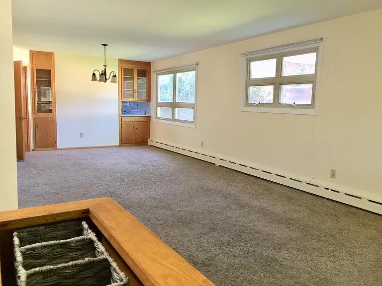 Spacious living room/dining room with built-in hardwood bookcase.
