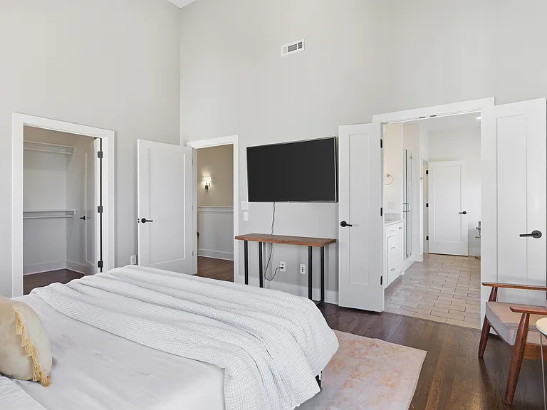 Primary bedroom on the 3rd floor with a king bed, Smart TV, ensuite bath, and room darkening shades. Includes a large walk-in closet. Tastefully decorated with high-end modern furnishings.