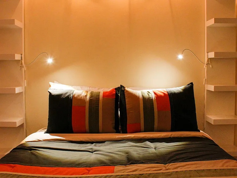 Bedroom #2, furnished with a queen size bed including shelving, reading lights and additional decorative lighting...
