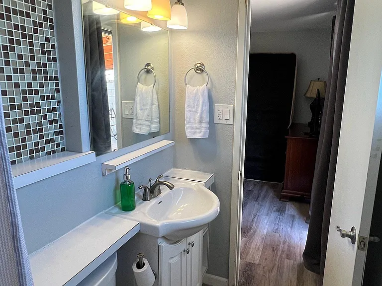 Well-kept bathroom with a single-sink vanity, framed mirror, and overhead lighting, plus easy-care flooring.