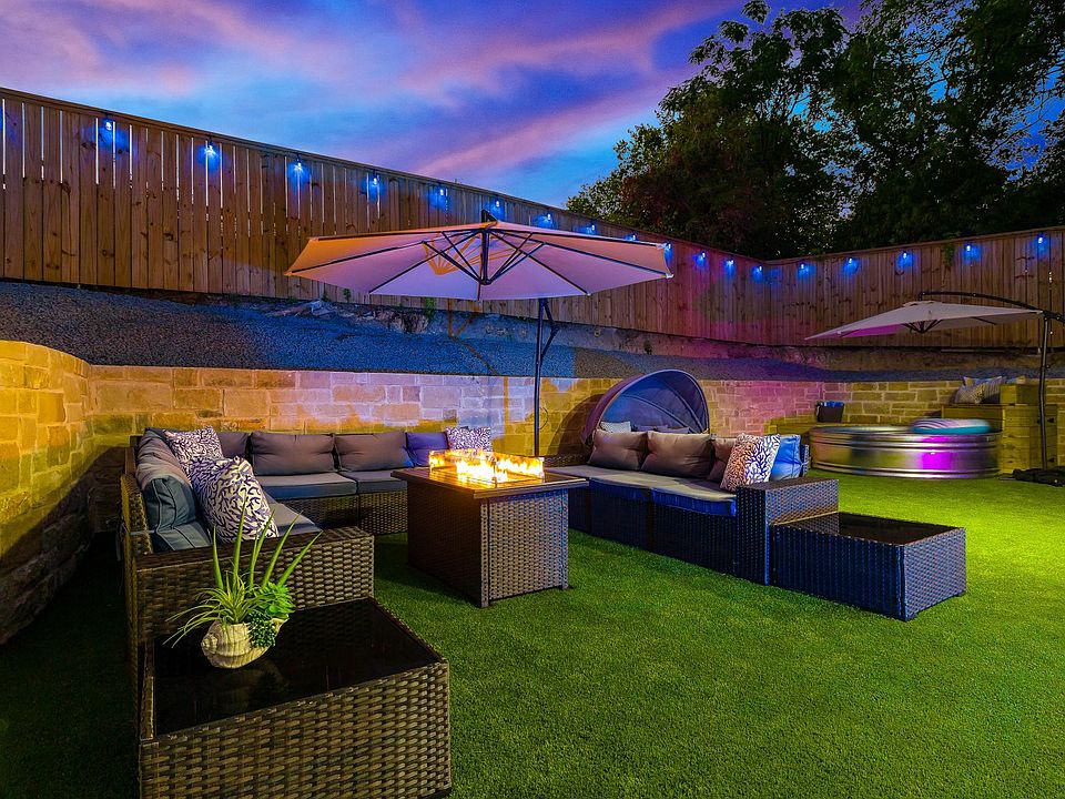 Backyard with turf, seating area/fire pit, Hot tub, plunge pool, porch seating, grill, string lighting.