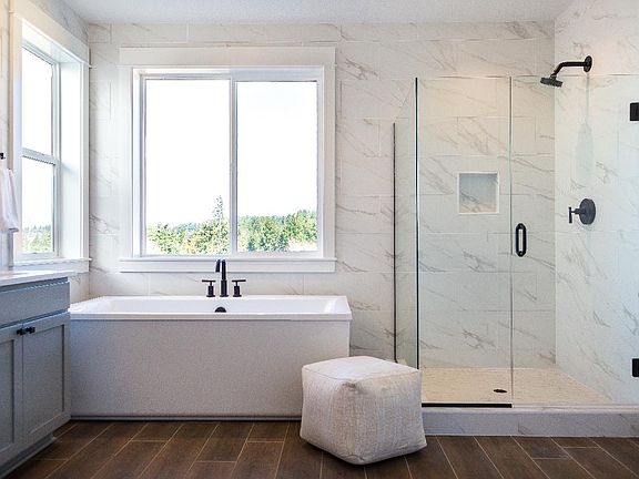 Free-standing tub, extended wall tile work and dual-sink vanity and upgraded lighting and fixtures