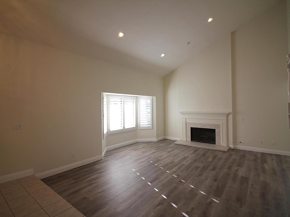 Living room has soaring ceilings with a classic New England style fireplace