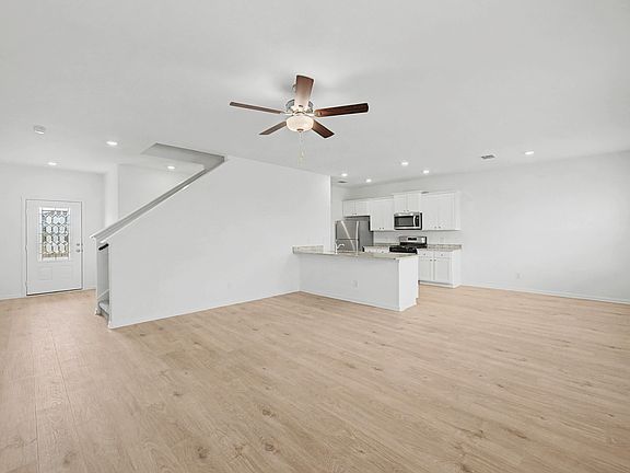 Open-concept layout with a spacious living room and upgraded kitchen.