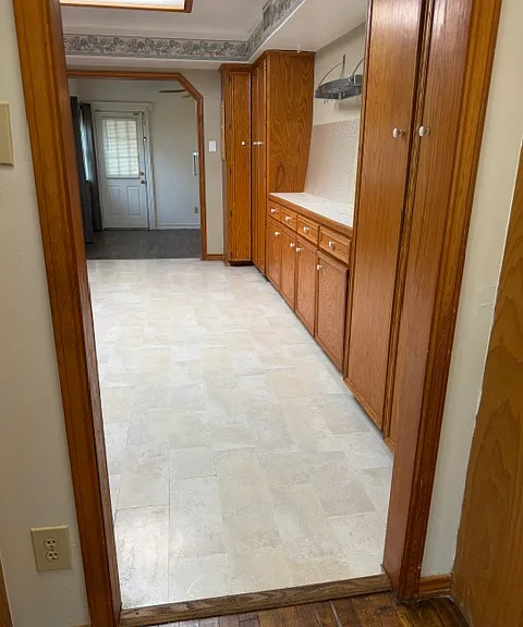 Kitchen is located between breakfast room and living room, includes ample storage and hanging rack for pots as well as loads of counter space.