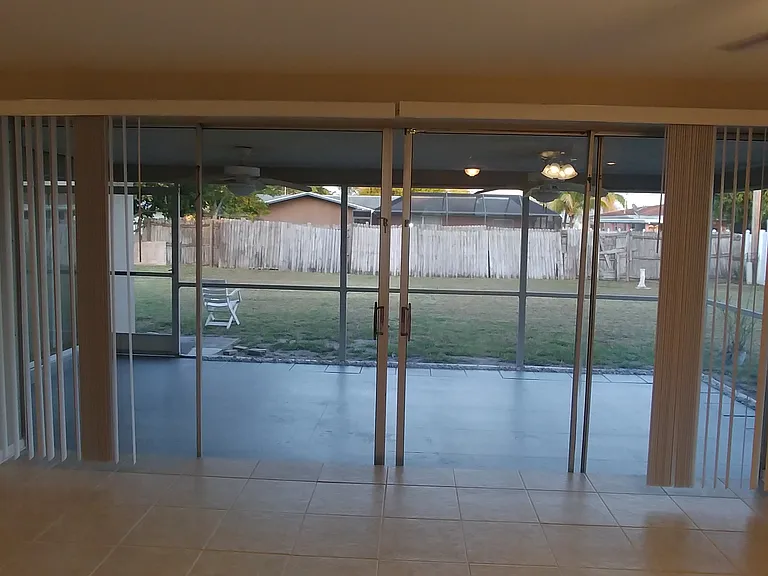 Looking through the expansive liv rm and out the large lanai into the rear yard. The perfect place to unwind and enjoy a cool drink on a warm day.