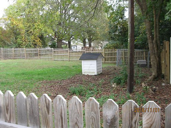 Pet friendly backyard with 2 dog houses and a kennel.