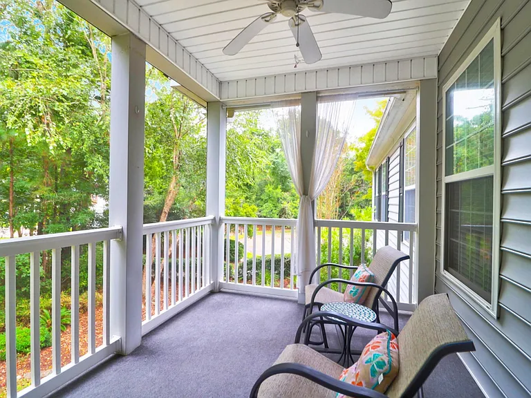 Deceptively large screened-in porch features a fan for summer days.