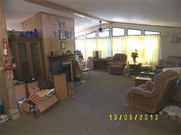 One view of the Living Room w a wood burning Fireplace. Owner passed away trying to pack things.