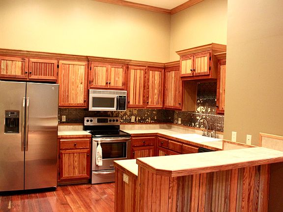 Kitchen has all stainless steel appliances: refrigerator, dishwasher, range, and microwave. Excess cabinet storage and step-up peninsula, perfect for a few barstools.
