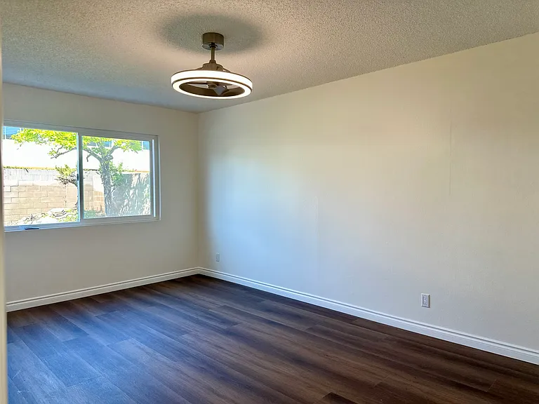 Primary suite bedroom on first floor, with new flooring, modern ceiling fan