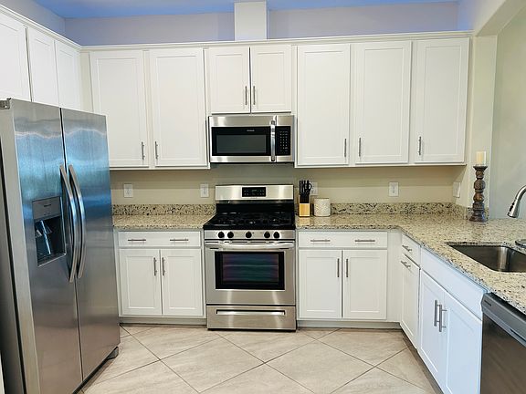 Spacious kitchen with gas cooktop and farmhouse sink and under cabinet lighting