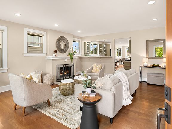 The home opens to a grand living space, with a cozy wood-burning fireplace serving as the anchor point for conversations.