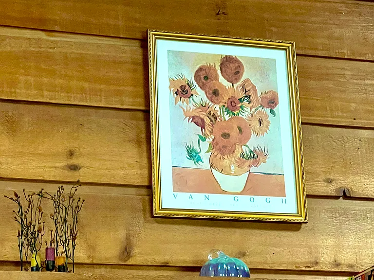 Vincent Van Gogh's Sunflowers hangs above the fireplace.