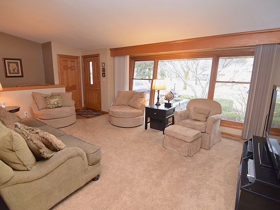 Open living room with cathedral ceiling and floor to ceiling windows, allowing for tons of natural sunlight 